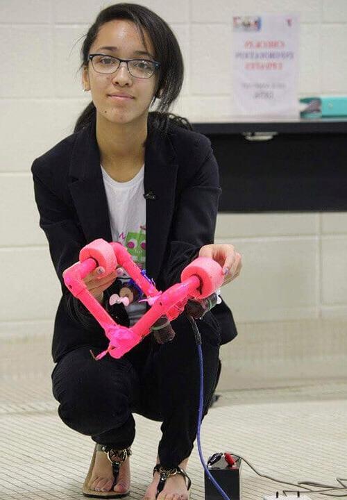 麦迪逊 holding a robot she created for a STEM project